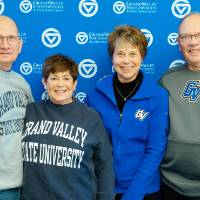 four alumni pose for a picture